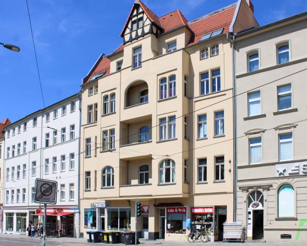 Städtische Straße mit historischen und modernen Gebäuden, Geschäften im Erdgeschoss.