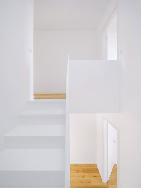Minimalistische, helle Treppe mit weißem Design und Holzfußboden, modernes Raumkonzept mit offenem Grundriss.